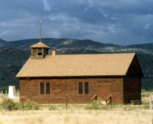A photo of the school from the broadside with bell tower on the left and mountains in the background.